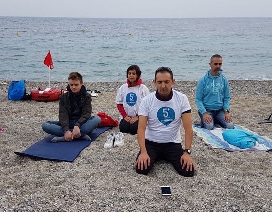 People meditating in front of ocean